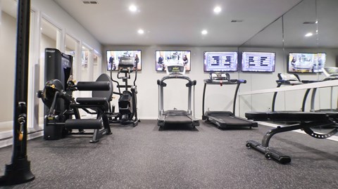 A gym with a variety of equipment including treadmills, exercise bikes, and weight machines.