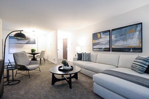 A living room with a grey couch, a black table, and a lamp.