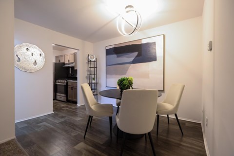 A modern dining room with a round table and chairs.