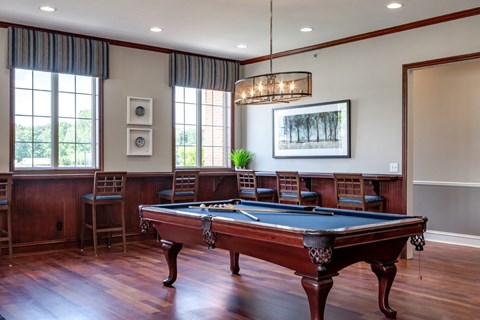 a game room with a pool table and chairs
