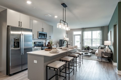 A modern kitchen with a large island and stainless steel appliances.