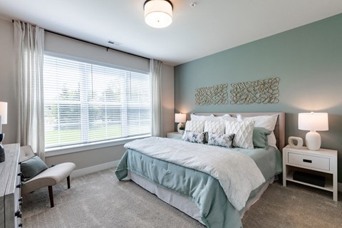 a bedroom with a bed and a large window