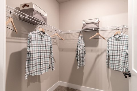 a closet with two shirts hanging on a rack and two shirts