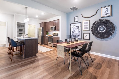 A kitchen with a dining table and chairs.