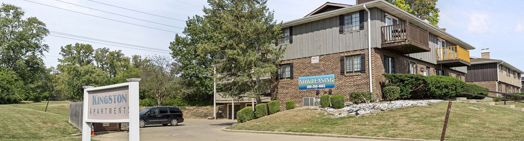 A building with a sign that says Kingston Apartments.