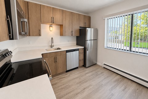 A kitchen with wooden cabinets and a black stove top oven.
