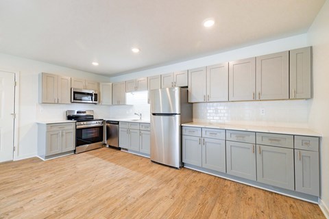 A kitchen with wooden floors and stainless steel appliances.