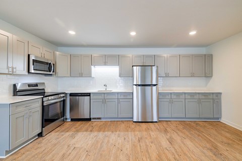 A kitchen with wooden floors and stainless steel appliances.