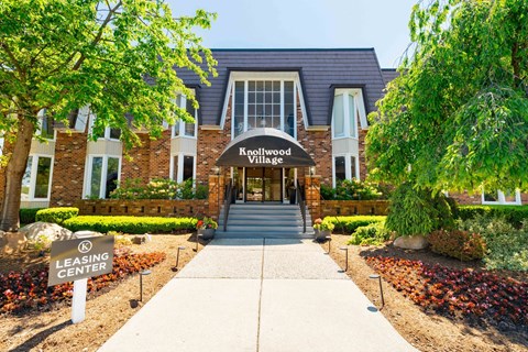 The entrance to Knollwood Village with a leasing center sign in front.