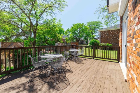 A wooden deck with a table and chairs.