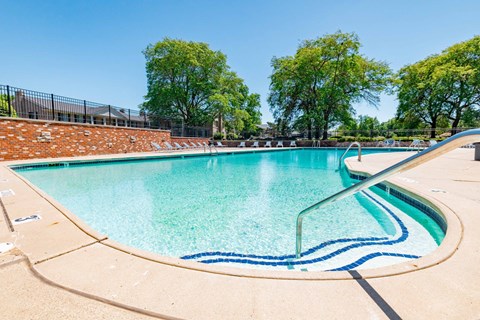 A large outdoor swimming pool with a blue line in the middle.