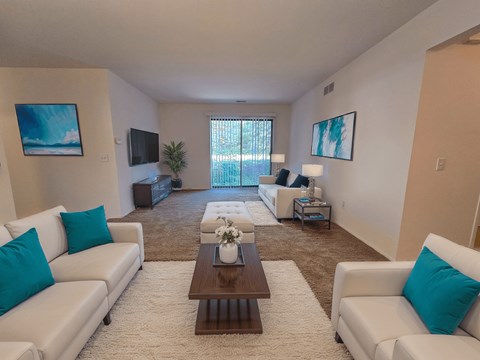 A living room with white couches and a brown coffee table.
