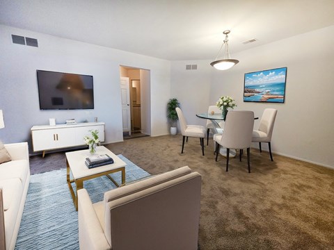 a living room and dining room with a table and chairs