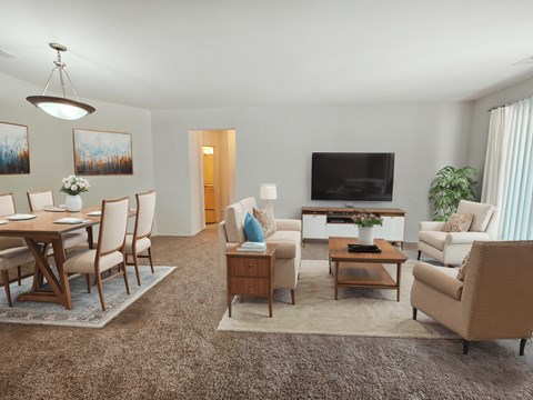 a living room and dining room with a table and chairs and a television