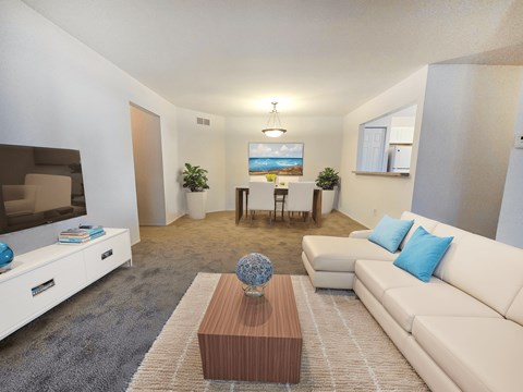 A living room with a white couch, a wooden coffee table, and a painting on the wall.