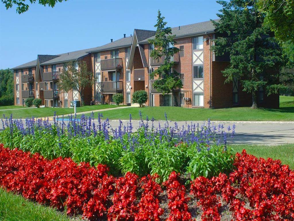 a flower garden in front of an apartment building