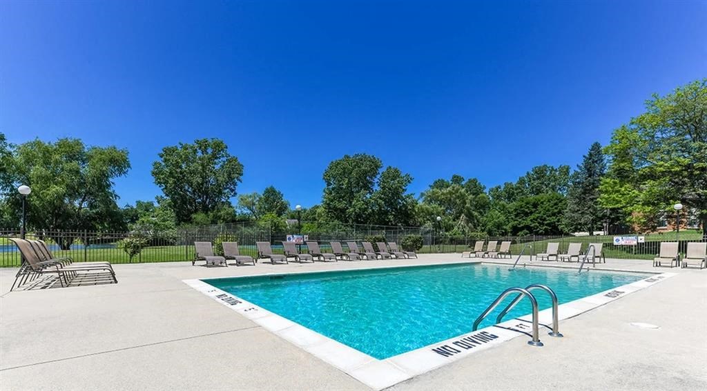 a swimming pool with chairs around it