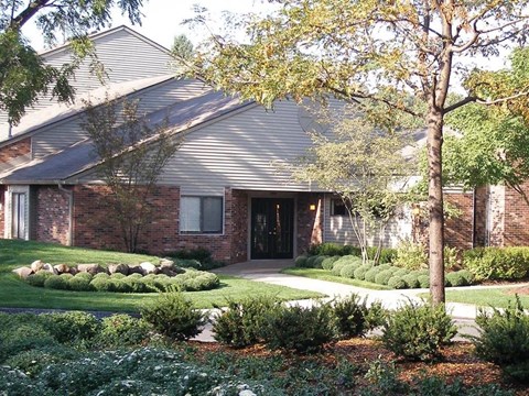 the front of a house with a yard and trees