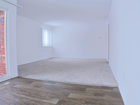 Empty room with a window and wooden flooring.