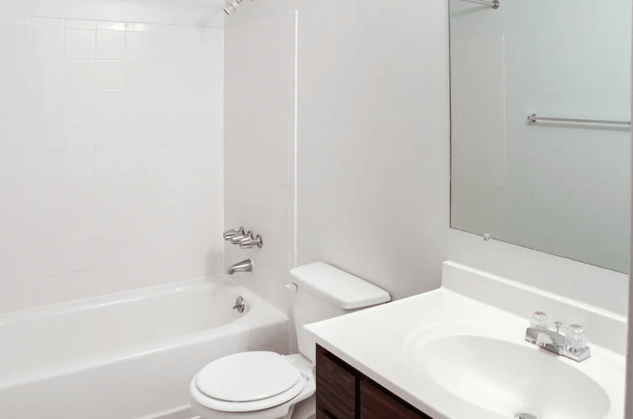 A white toilet sits next to a white sink in a bathroom.