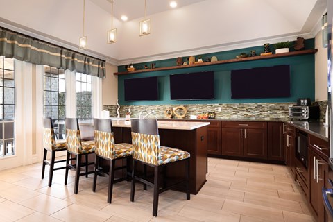 A kitchen with a table and chairs in front of a window.