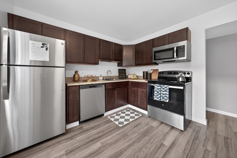 A kitchen with a stainless steel refrigerator and microwave.