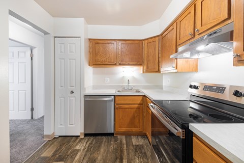 A kitchen with wooden cabinets and a black stove top oven.