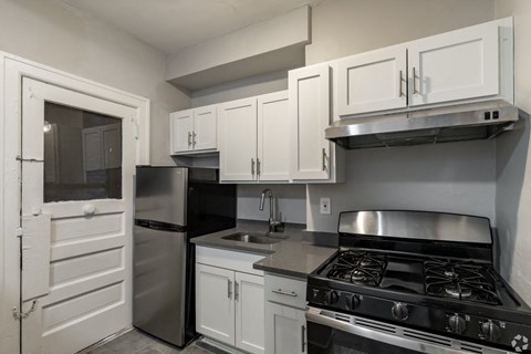 a kitchen with white cabinets and stainless steel appliances