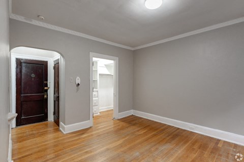 a living room with a door and a hard wood floor