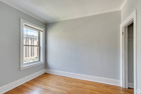 an empty room with wood floors and a window