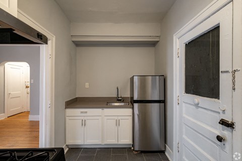 a kitchen with a stainless steel refrigerator and white cabinets