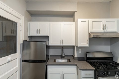 A kitchen with white cabinets and a black stove.