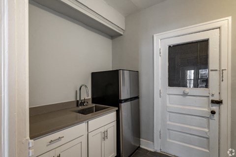 a kitchen with a refrigerator and a sink and a door