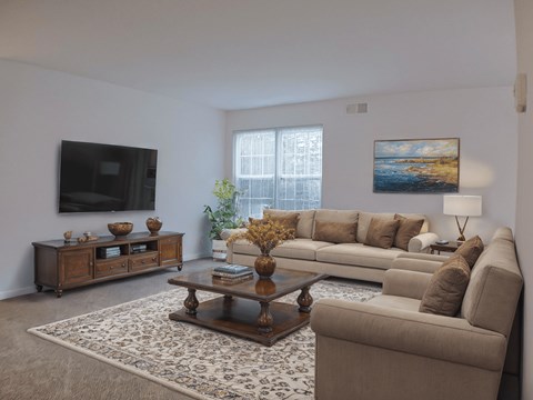 A living room with a couch, coffee table, and a painting on the wall.