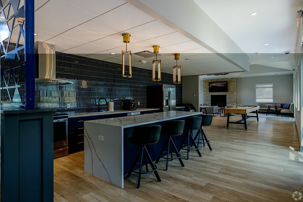 a kitchen and dining room with blue chairs and a large island with a counter