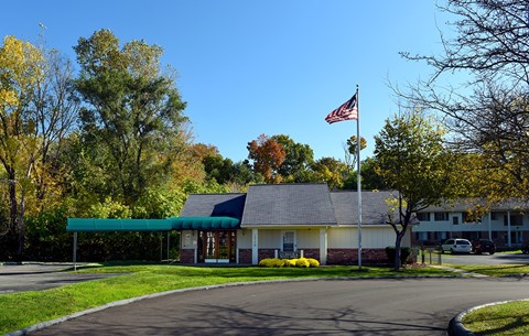 A building with a flag on top is surrounded by trees.