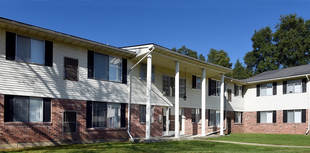 A white building with a porch and a covered walkway.