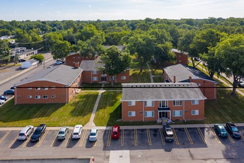 A parking lot with cars and a building in the background.