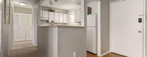 A kitchen with white appliances and cabinets.