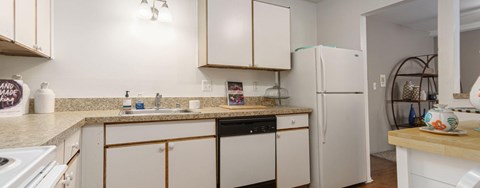 A kitchen with white appliances and cabinets.
