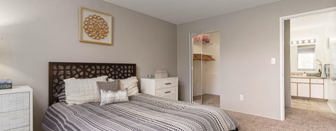 A bedroom with a bed, dresser, and mirror.