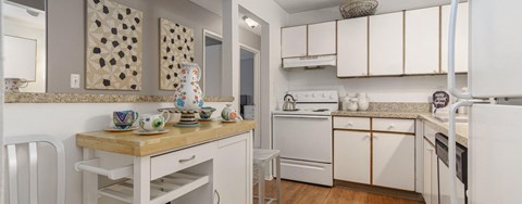 A kitchen with white appliances and a wooden island.