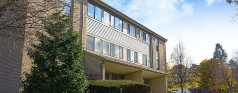 A modern building with a grey facade and large windows.