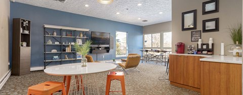 A dining room with a white table and orange chairs.