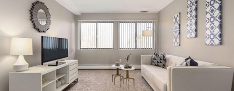 A living room with a white couch, a television, and a coffee table.