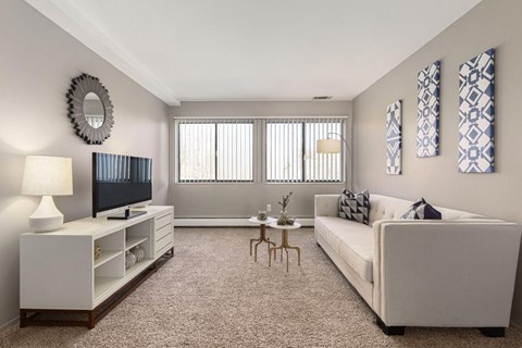 A living room with a white couch, a television, and a coffee table.