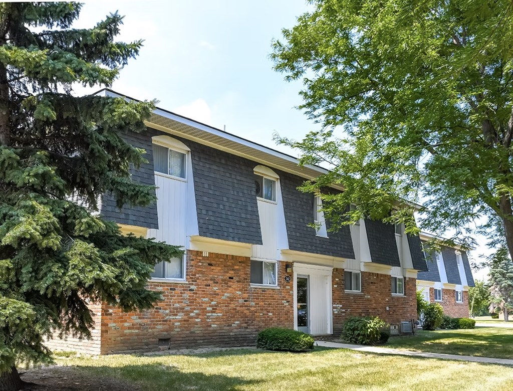 A brick house with a white door and windows.