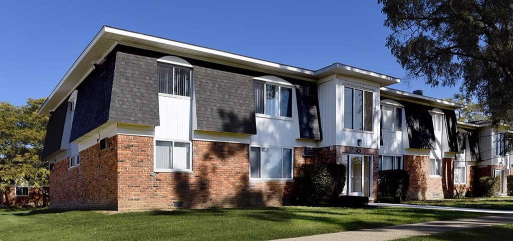 A row of houses with a green lawn in front.