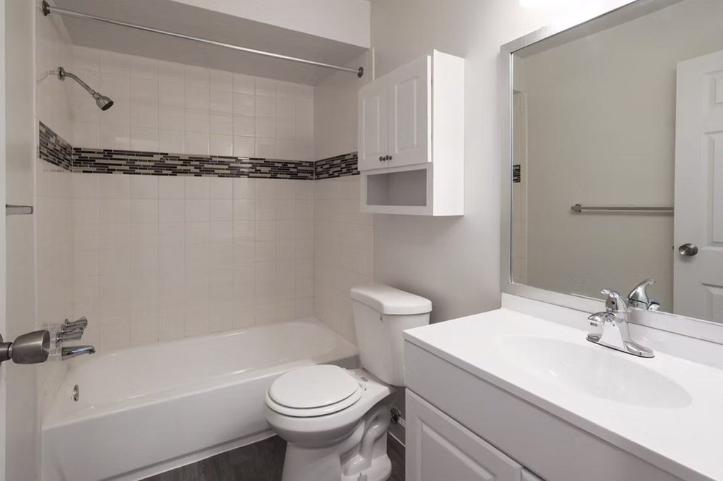 A white bathroom with a toilet, sink, and bathtub.