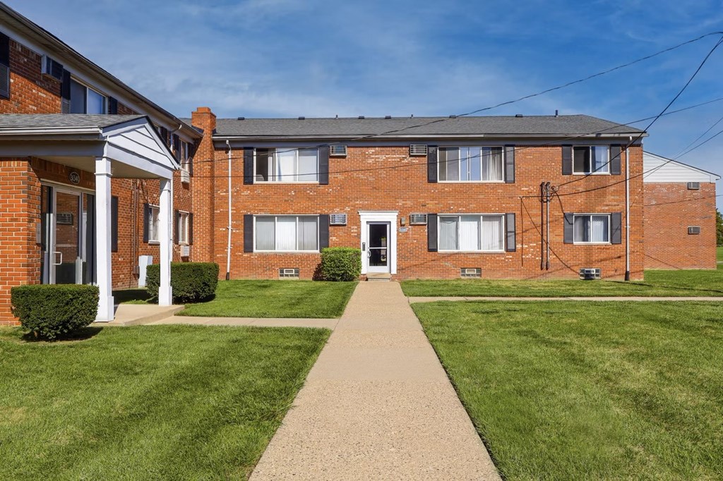 A brick building with a white door and windows.